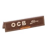 OCB Kingsize Slim Virgin papir fremstår i en mørkeblå emballage med guld- og hvide detaljer. Papiret har en fin, glat tekstur og er prydet med et subtilt logo i guld. Størrelsen er lang og smal, hvilket giver et slankt indtryk. Æsken har en praktisk lukning, der sikrer, at indholdet forbliver beskyttet.
