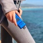 En slank, bærbar vaporizer med en mat sort finish pryder overfladen. En oval, digital skærm viser temperaturindstillinger i klart, hvidt tal. Der er en enkel knap til betjening, placeret på siden. Den ergonomiske form sikrer et godt greb, mens et lille mundstykke i rustfrit stål stikker ud fra toppen. Ventilationshuller er synlige på bagsiden.