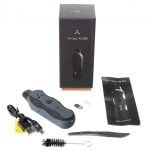 AirVape XS GO præsentere en slank, kompakt form med en mat, sort overflade. Den har en buet top og en let afrundet bund, hvilket giver et ergonomisk greb. En digital skærm viser temperaturindstillinger, mens knapperne er placeret strategisk til nem betjening. En gennemsigtig skuffe til urter er synlig, med en rustfri stålrist indeni.