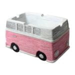 Et askebæger i form af en klassisk Volkswagen bus præsenterer sig i en lys pink farve. Det har en glat, blank overflade, der reflekterer lys. Bægeret er detaljeret med sorte vinduer og hvidt bildesign, som fremhæver bilens karakteristiske træk. Formen er rund i bunden og afsluttes med et fladt låg, der lukkes tæt.