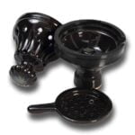En sort tobaksfyldt shisha-topskål med en glat, blank overflade. Skålen har en oval form med en let hældning mod midten, hvor en rund åbning er synlig. Kanten er tynd og skarp, og der er et subtilt mønster af linjer, der løber langs skålens ydre. Den sorte farve giver et elegant udtryk.