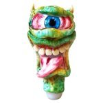 En sort glasrør, formet som et monster med en skælvende lizard-lignende struktur. Overfladen er glat med en blank finish, der reflekterer lys. Røret har en kurvet form med detaljerede, farverige elementer, der ligner øjne og tænder. Målene er omtrent 150 mm i længden, og der er en tydelig, bred åbning i den ene ende.