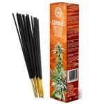 Cannabis røgelsespinde præsenteres med tørrede cannabisblade og friske mangostykker. Røgelsespindene er lange og slanke, med en mørkebrun farve og en ru overflade. De tørrede cannabisblade er grønne med nuancer af brun og har en sprød tekstur. Mangostykkerne har en dyb gul-orange farve og en glat overflade, som kontrasterer med de grønne blade.
