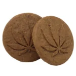 Euphoria cannabis cookies præsenteres i en klar, genkendelig emballage med en mørk baggrund og farverige grafiske elementer. Foran er der en stor, hvid tekst, der angiver produktnavnet, omkranset af grønne og gule detaljer. Emballagen har en mat overflade med en let struktur, der giver en luksuriøs følelse. Nederst ses en tekstbox med information om indholdet.