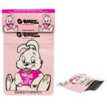 En rulle tape med en pink baggrund prydet af sorte grafiske elementer. Stilen viser en kombination af skrift og symboler, hvor teksten "Thug for Life" fremstår i en markant skrifttype. Tapeens overflade har en glat tekstur, og kanterne er lige og præcise. Dimensionerne er angivet som 65 x 85 mm.