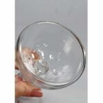 Glas vandpibehoved med en domformet top, fremstillet af klart glas, der giver en gennemsigtig og glat overflade. Den udvidede bund skaber en bred base, mens en slank hals fører til en åbningsåbning. Indvendigt ses en fin struktur, som kan bidrage til røgens kvalitet. Kanten er jævnt slebet for at sikre en tæt pasform.
