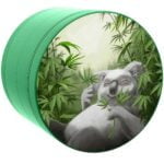 En 63 mm grindnation koala er præsenteret med en rund, flad form. Overfladen er dækket af en blød, mat tekstur i nuancer af grå og sort, med detaljerede mønstre og en stiliseret koala-illustration. Kanten er let afrundet, mens midten har en glat finish. Der er tydelige linjer og konturer, der fremhæver dyrekarakterens træk.