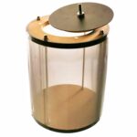 En rund tromme med en mesh-overflade præsenteres i en mørk farve. Trommens ramme er lavet af metal med en mat finish, der giver et industrielt udtryk. Mesh-materialet er stramt og jævnt, hvilket skaber en fin struktur. Der ses et enkelt logo i kontrastfarve, der er placeret centralt på trommen, som tilføjer et grafisk element.