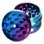 En diamantformet krydderkværn med en diameter på 50 mm præsenterer sig i en metallisk sølvfarve. Overfladen har en glat tekstur, mens de indvendige tænder er skarpe og har en vinkelret struktur for effektiv kværning. Kværnen er opdelt i to sektioner, og en lille hængslet lås sikrer, at den forbliver lukket under brug.