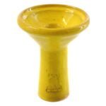 Kaya shisha i dyb ler med en glaseret overflade i en klar gul farve. Skålen har en rund form med en let udvidelse mod toppen og en flad bund. Den blanke glasur skaber en glat tekstur, mens den dybe lerfarve fremhæver materialets naturlige egenskaber. Der ses ingen synlige knapper eller symboler, kun en ensartet farve.