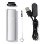 PAX Mini vaporizer præsenterer en slank, sølvfarvet krop med en minimalistisk og strømlinet form. Overfladen har en mat finish, der giver en stilren tekstur. En enkelt knap er placeret centralt, omgivet af bløde kurver. Den nederste del indeholder en magnetisk lukning, som afslører en keramikindsats til urter. Indikatorlys viser en status for enheden.