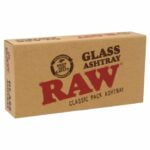 En rund askebæger i klart glas med en diameter på 16 cm. Det har en glat overflade, der reflekterer lys, og en tyk bund, som giver stabilitet. Askebægeret har tre udskæringer langs kanten til at placere cigaretter, hvilket tilføjer funktionalitet. Glasmaterialet fremhæver dets gennemsigtighed og enkle design.