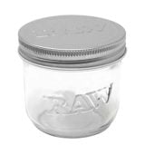 Et gennemsigtigt glas mason jar med en kapacitet på 295 ml. Glasset har en glat overflade, der reflekterer lys, og en let buet form med en bred åbning. Låget er metalfarvet, med en skruefunktion, der sikrer tætsluttende lukning. Jarret har en let ribbet struktur langs kanten, hvilket tilføjer tekstur til designet.