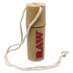 En stor, rund flaske med en mørk brun glasoverflade pryder midten. Flasken har en elegant, slank hals og en bred, flad bund. Et rustikt label i mørke nuancer med hvid tekst og guld kanter pryder flaskens front. Omkring flasken ses et naturligt træunderlag med en grov overflade, der tilføjer en organisk dimension til præsentationen.