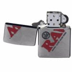 En sølvfarvet lighter i metal med en blank, reflekterende overflade. Den har en klassisk rektangulær form med afrundede kanter. Øverst er der en hængslet låg, der åbner opad. Lighterens front er prydet med et indgraveret mønster, der tilføjer tekstur. Knapperne til tænding er placeret på siden, fremtrædende med en sort overflade.