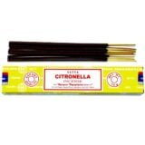 Røgelsespindene er lange og slanke, fremstillet af mørkebrunt materiale med en glat overflade. De er pakket i en gennemsigtig plastikpakke, der har et minimalistisk design. Etiketten er hvid med grønne og sorte skrifttyper, som præsenterer produktnavnet "Satya Citronella". Baggrunden er lys, hvilket fremhæver røgelsespindene og emballagens detaljer.