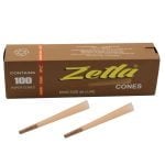 Brune coner i king size, samlet i en bunke, fremstår i en glat og ensartet tekstur. Hver cone har en spids ende og en bredere base, hvilket skaber en konisk form. Det brune papir har en mat finish uden mønstre. Konerne er stablet, hvilket giver en struktureret og organiseret præsentation.
