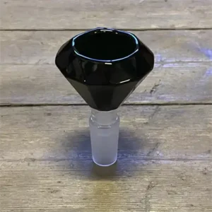 Bonghovedet i sort glas præsenterer en elegant, diamantformet struktur med facetter, der skaber dybe refleksioner og lysglimt. Den glatte overflade har en blank finish, som fremhæver de skarpe kanter og detaljerede mønstre. Hovedet har en solid base og en slank hals, hvilket giver et stilfuldt og moderne udtryk. Farven er dyb sort, hvilket tilføjer en sofistikeret tone.