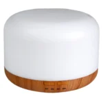 Aroma diffuseren har en cylindrisk form i en trælook-finish med en glat overflade. Øverst er der en rund, hvid plastikdel, der indeholder en diffuseråbning. En USB-port er placeret i bunden, omgivet af en sort gummiring. Diffuseren har en knap i midten til betjening, og et subtilt lys kan ses omkring åbningen.