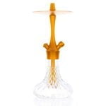 En gylden lampe med en glitrende overflade pryder midten, udsmykket med detaljerede mønstre og bløde kurver. Lampens fod er bred og stabil, mens skærmen har en let skrå form, der skaber en elegant silhuet. Lysrefleksioner fra den metalliske finish tilføjer en varm glød, og de fine ornamenter skaber en fortryllende atmosfære.