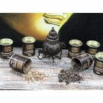 Røgelse af frankincense i små, uregelmæssige stykker præsenteres på en hvid overflade. De gennemsigtige, gyldne stykker har en let glinsende overflade og varierer i størrelse og form. Nogle stykker har en let brunlig nuance, mens andre er mere klare. Den fine struktur afslører en naturlig, harpiksagtig tekstur, der indikerer røgelsens oprindelse.