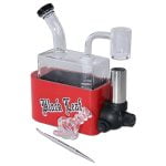 En rektangulær rejsebeholder i sort, fremstillet af metal, prydet med et gråt bladmotiv. Beholderens overflade har en mat finish, mens den nederste del er udstyret med en rød, cylindrisk lighter med en glat tekstur. Lighterens top har en trykknap til tænding, og der er en synlig brændstofåbning. Hele enheden måler cirka 16 cm i længden.