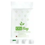 En transparent plastikpose indeholder et hvidt, fint pulver, der er samlet i bunden. Posen har en lukning, der er forsynet med en sort tekst, der angiver indholdet som CO2. Øverste del af posen er let krøllet, og der er en tydelig kant øverst, hvilket giver en struktureret form.