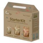 Et sæt til havearbejde præsenterer sig med en række jordbrune potter i forskellige størrelser, hver med en glat overflade. De er fyldt med mørk, næringsrig jord. En klar plastikkande med en lang tud står ved siden af, mens en hvid etikette med grøn skrift angiver indholdet. Baggrunden er neutral, hvilket fremhæver potterne og kanden.
