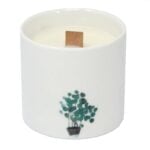 To store, cylindrisk stearinlys pryder en overflade. Begge lys er dekoreret med et botanisk mønster i nuancer af grøn, hvid og beige. Mønsteret viser detaljerede blade og blomster, der skaber en organisk følelse. Lysene står i en let skrå vinkel, hvilket fremhæver deres glatte overflade og den matte tekstur.