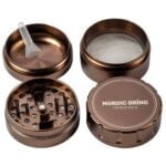 En rund, bronze farvet pendelarmatur med en mat overflade pryder det centrale område. Den har en diameter på 60 mm og fremstår med bløde kurver og en simpel, elegant form. Skærmen er lukket i bunden, hvilket skaber en ensartet lysfordeling. Den hænges op med en sort ledning, der bidrager til det minimalistiske udtryk.