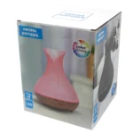 En aromadiffuser i form af en halvåben skal, fremstillet af lyst træ med en glat overflade. Den har en rund base med en USB-port, og en del af skallen er dekoreret med et vævet mønster, der skaber dybde. Diffuseren er udstyret med en enkelt knap til betjening, der er placeret på forsiden. Farverne spænder fra beige til lysebrun.