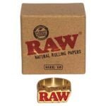 En ring fremstillet af råguld med en ujævn overflade, som skaber en organisk og rustik tekstur. Ringen har en bred, solid form og en let buet inderside. Den gyldne farve varierer i intensitet, hvilket giver en dybde til metallet. Ingen synlige dekorationer eller indgraveringer pryder ringen, hvilket fremhæver det enkle design.