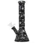 En sort bong med et kranium-design pryder toppen. Den har en glat, blank overflade og er fremstillet af glas. Bongen er 26 cm høj og har en buet form, der giver den en elegant silhuet. Højden er markeret af en bred, stabil bund, mens det kranielignende motiv tilføjer et dramatisk element til det samlede udtryk.