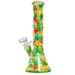 En bong med en højde på 26 cm præsenterer sig i klare farver, domineret af grønne og gule nuancer med røde detaljer. Den har en oval base og en slank, cylindrisk hals. Mønsteret af stiliserede blade dækker overfladen, hvilket skaber en livlig og organisk tekstur. En glasperle fungerer som en stopper, og en skål til urter er placeret ved siden af.