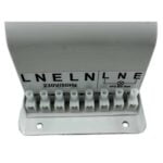 En cylindrisk ballast med en mat sort overflade pryder midten af billedet. Den har en glat tekstur og en tydelig skruemekanisme i bunden. Øverste del er let buet, hvilket skaber en harmonisk form. Omkring ballasten ses små, skarpe detaljer, som kan indikere montagerester eller tilslutningspunkter. Baggrunden er neutral og fremhæver objektets konturer.
