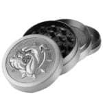 En metalgrinder med en diameter på 50 mm præsenterer sig i en sølvfarvet overflade med en let børstet finish. Grinderens øverste del har en skarp tandstruktur til effektiv kværning. En lille logo gravering er placeret centralt. Den nederste del har små lufthuller, der muliggør nem adskillelse af det kværnede materiale. Kanten er let afrundet for bedre greb.