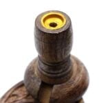 Rundt, skulpturelt element fremstillet af mango-træ med en glat, naturlig finish. Overfladen viser en varm, gyldenbrun farve med lette, mørkere åretegninger. Det centrale design inkluderer en oval form og en hul indvendig del, der skaber plads til røg. Detaljer omfatter en cirkulær base og en let hævet top med en åbning til røgudslip.