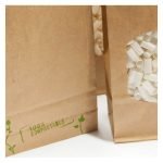 Jilter biofiltre præsenteres i en transparent plastikpose, der indeholder 1000 enheder. Filtrene er hvide, runde og flade med en let tekstureret overflade. Hver enhed er omkranset af en tynd kant, der sikrer stabilitet. Posen har et klart trykt logo og information på forsiden, mens bagsiden er simpel med et hvidt design.
