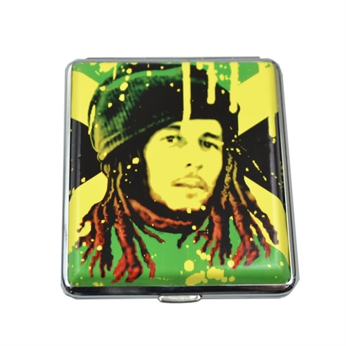 Cigaretetuiet har en rektangulær form med afrundede kanter. Det prydes af farverige motiver, der viser et stiliseret billede af Bob Marley og Jamaicas flag. Baggrunden er domineret af grønne, gule og sorte nuancer, som skaber en livlig kontrast. Materialet ser ud til at være metal med en glat, blank overflade, der kan reflektere lys.