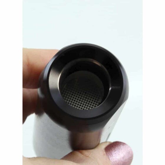 Cigarvaporizer i sort, fremstillet af glat metal med en mat overflade. Den har en afrundet form med en let buet top og en bred base. En tydelig, sølvfarvet knap sidder centralt, omkranset af et diskret mønster. Ventilationshuller er placeret langs siden, og produktet har en elegant, minimalistisk æstetik, der understreger funktionalitet.