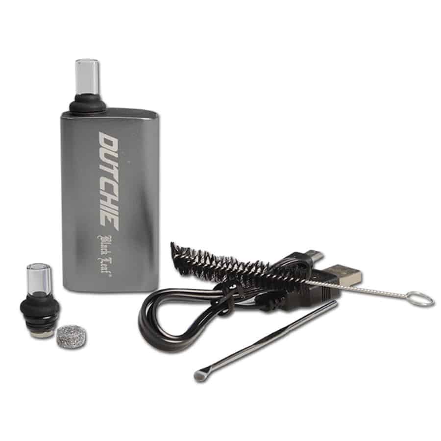 En grå vaporizer præsenterer sig med et glat, mat ydre, der har en subtil tekstur. Den har en afrundet form med en let buet top og en diskret, rund knap på fronten. Logoet i form af et bladværk er placeret på siden i en mørkere nuance. En gennemsigtig beholder til væske eller olie ses i bunden, hvilket skaber en kontrast til det grå.