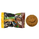 En skål med småkager præsenterer sig med en gyldenbrun overflade, prydet med store stykker mørk chokolade. Småkagerne har en let krakeleret tekstur, og nogle af dem har en blød, uregelmæssig kant. Den bageste del af skålen er dækket af et let lag melis, hvilket giver et kontrastfyldt udseende mod den varme farve.