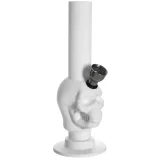 En lille bongs i hvidt, fremstillet af gummi, præsenterer en skulpturel kraniumform. Den er 15 cm høj med glatte, bløde kurver og tydelige ansigtstræk. Overfladen har en mat tekstur, mens mundstykket er placeret øverst. Der er en lille åbning til vand ved bunden, hvilket tilføjer funktionalitet til det unikke design.