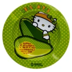 Askeholderen præsenterer en rund form med bløde kanter, udført i keramik. Overfladen er dækket af en lys, pastelgrøn farve, der skaber en blid kontrast til de detaljerede, farverige illustrationer af Hello Kitty og avocadoer. Mønsteret er legende og grafisk, med klare linjer og farver, der tilføjer en livlig stemning.