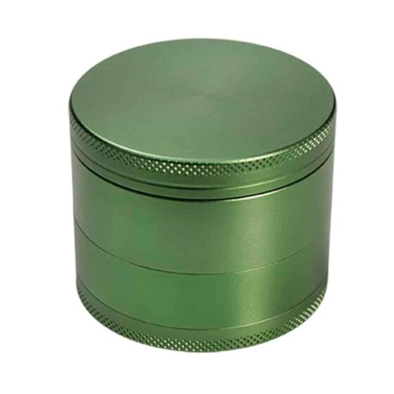 En grøn, rund masher grinder med en diameter på 52 mm. Overfladen har en glat, mat finish, mens kanterne er let buede. Der er små, præcise tænder indvendigt til at male krydderier. Låget har en skruefunktion, hvilket sikrer en tæt lukning. Farven er ensartet med en subtil glans, der giver et moderne udseende.