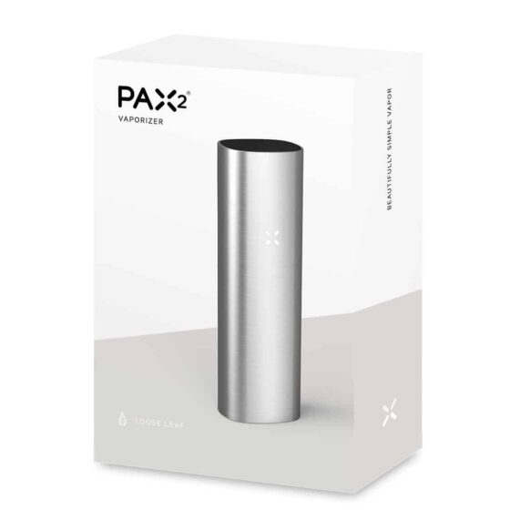 PAX 2 enheden præsenterer sig i en slank, rektangulær form med afrundede hjørner. Den har en glat, sølvgrå metaloverflade, der reflekterer lys. Enheden har et minimalistisk design uden synlige knapper, men en lille, diskret LED-indikator. Tilbehøret inkluderer en sort silikonebeskytter og en oplader med et fladt, rektangulært design, der matcher enhedens stil.