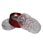 En akryl grinder i transparent materiale præsenterer sig med en rund form og en diameter på 55 mm. Overfladen har en glat, skinnende tekstur, mens den øverste del er dekoreret med små, skarpe tænder til formaling. En magnetisk lukning sikrer, at de to dele holdes sammen, og der er en finmasket si i bunden til opsamling af pollen.