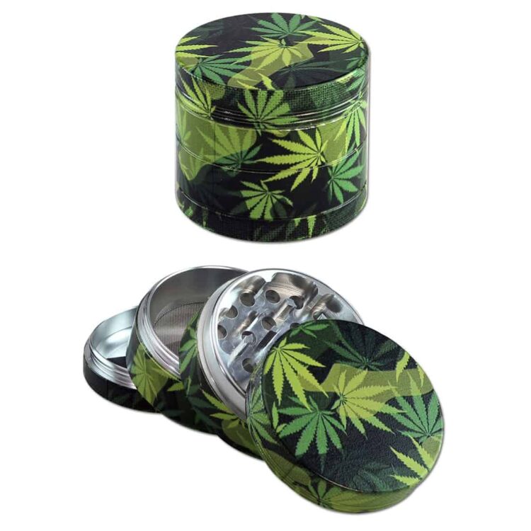 En sort grinder med et bladkamuflage-mønster pryder overfladen. Den har en rund form og en glat, mat tekstur, der kontrasterer med de fine, detaljerede, grønne og brune nuancer af kamuflage. Grinderen har små, stikkende tænder indvendigt, der er designet til at male urter. Den har en skruelukning, der sikrer en tæt forsegling.