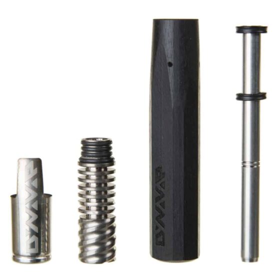 VapCap vaporizer præsenterer en slank, cylindrisk form i rustfrit stål med en børstet overflade. Den har en konisk top med en glat kant og et lille, afrundet mundstykke. Overfladen er prydet med fine teksturer og detaljerede udskæringer. Farven er ensartet sølvgrå, og en diskret logoindgravering ses på siden. Generelt har enheden et minimalistisk og moderne udtryk.