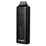 En kompakt vaporizer med en mat sort overflade, der fremstår strømlinet og moderne. En digital skærm er placeret på forsiden, omgivet af tydelige knapper til betjening. En sølvgrå rist er synlig på toppen, hvor dampen udledes. En genopladelig batteribank er integreret i designet, hvilket giver en praktisk og funktionel æstetik.